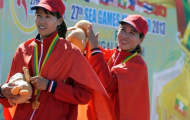 Hai cô gái vàng rowing phấn khích trên bục nhận huy chương