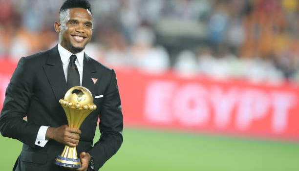 Huyền thoại Cameroon ăn mặc bảnh bao dâng cúp vô địch CAN cho Riyad Mahrez